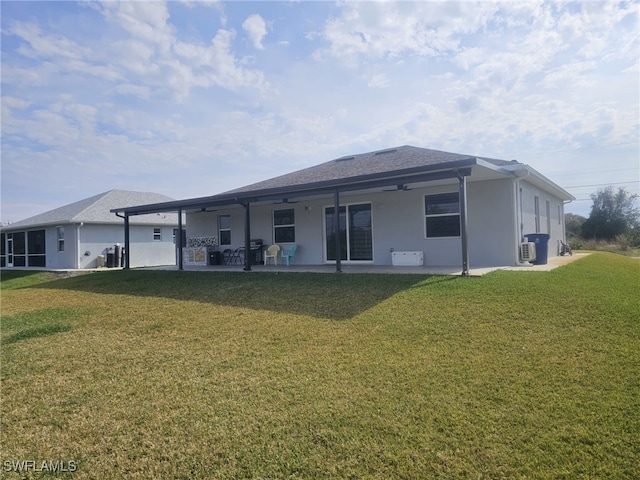 rear view of property featuring ceiling fan, a yard, and a patio