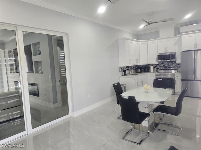 dining space with ceiling fan and crown molding