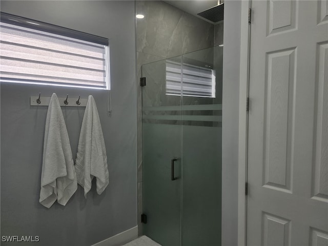 bathroom with a shower with door