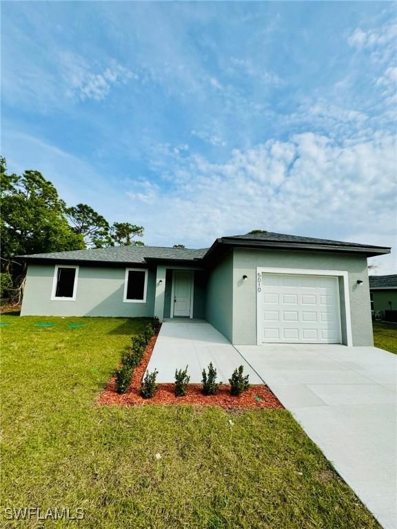 ranch-style home featuring a front lawn and a garage