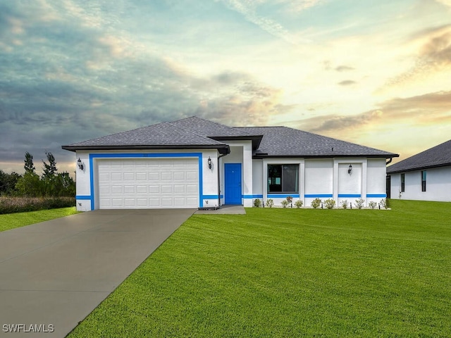 prairie-style home featuring a garage and a lawn