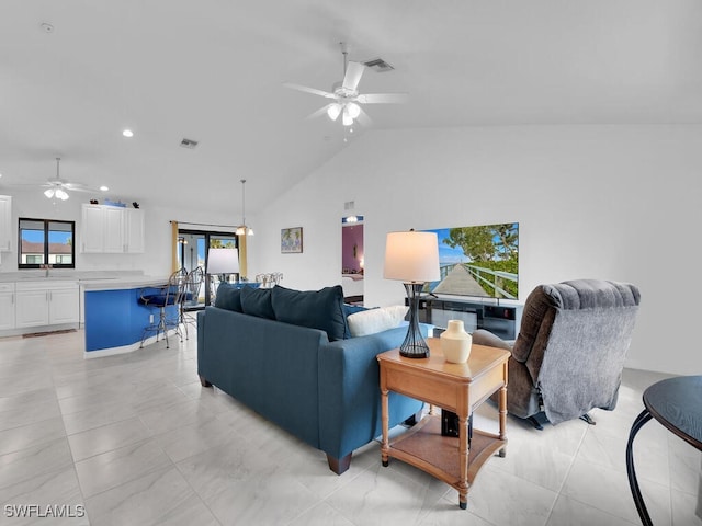 living room with ceiling fan, high vaulted ceiling, and sink