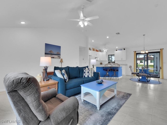 living room with high vaulted ceiling and ceiling fan with notable chandelier