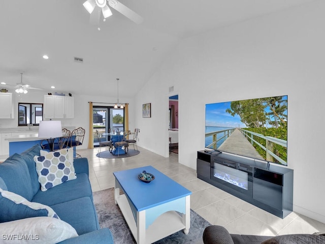 living room featuring ceiling fan, light tile patterned floors, and high vaulted ceiling