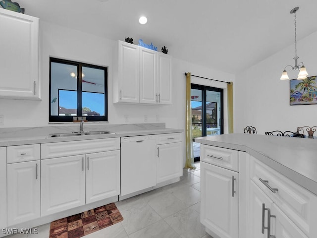 kitchen featuring sink, decorative light fixtures, white dishwasher, a wealth of natural light, and white cabinets