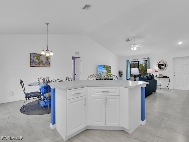 kitchen with pendant lighting, lofted ceiling, white cabinets, a kitchen island, and ceiling fan with notable chandelier