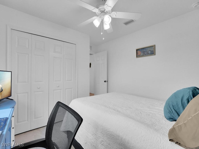 tiled bedroom featuring ceiling fan and a closet