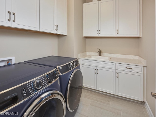 laundry room featuring cabinets, separate washer and dryer, and sink