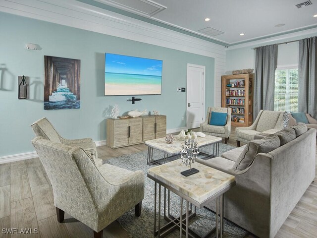 living room with ornamental molding and light wood-type flooring