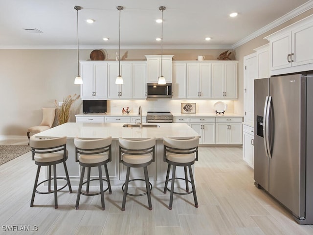 kitchen featuring white cabinetry, stainless steel appliances, sink, and hanging light fixtures