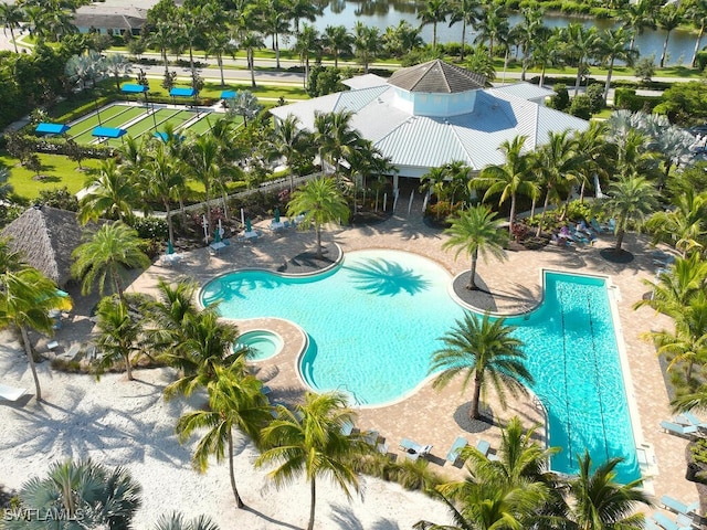 view of pool with a community hot tub, a water view, and a patio area