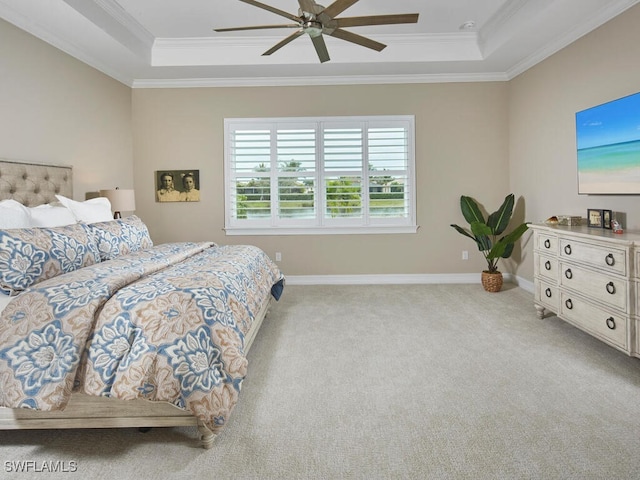 bedroom with crown molding, light carpet, and a tray ceiling