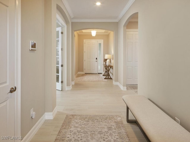 corridor with crown molding and light hardwood / wood-style floors