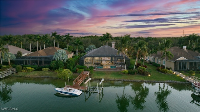 aerial view at dusk featuring a water view