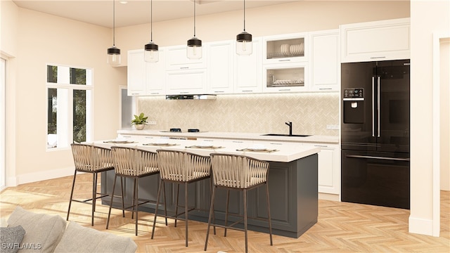 kitchen with white cabinets, tasteful backsplash, a kitchen island with sink, and black fridge with ice dispenser