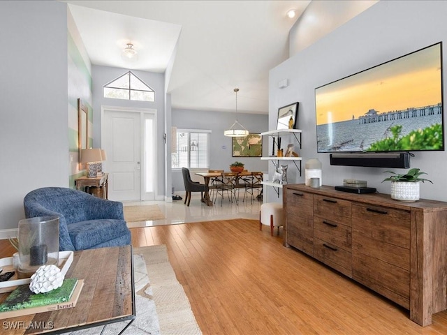 living room featuring lofted ceiling and light wood-type flooring