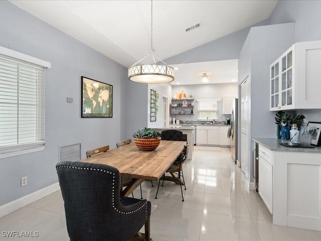 tiled dining space with lofted ceiling