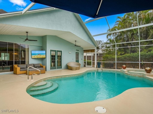 view of swimming pool featuring ceiling fan, glass enclosure, a patio area, and an in ground hot tub