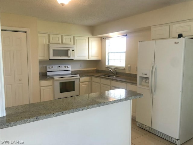 kitchen with white cabinetry, sink, white appliances, and light tile patterned floors