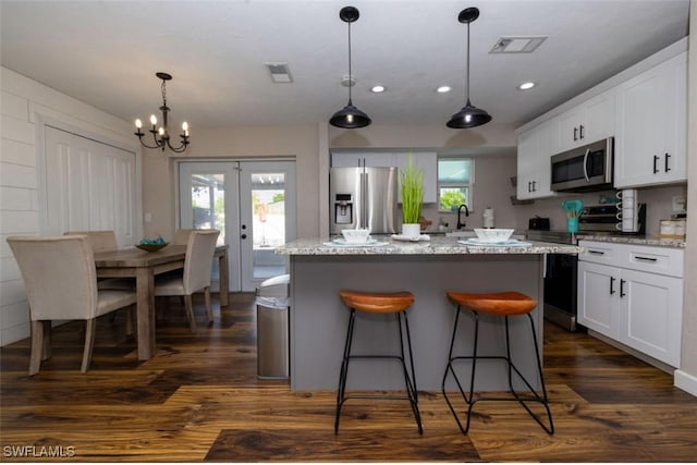 kitchen with dark wood-type flooring, french doors, appliances with stainless steel finishes, and white cabinetry