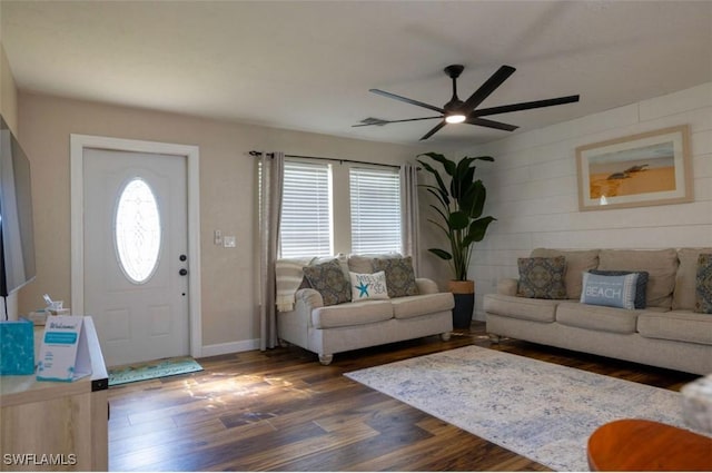 living room with dark wood-type flooring, ceiling fan, and a healthy amount of sunlight