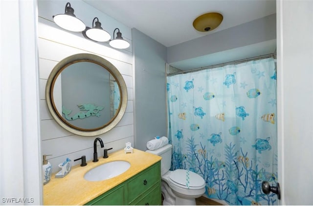 bathroom featuring toilet, vanity, wooden walls, and walk in shower