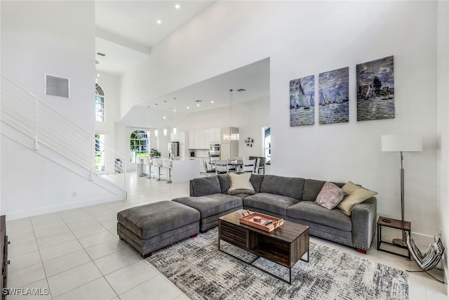 living room with a towering ceiling and light tile patterned floors