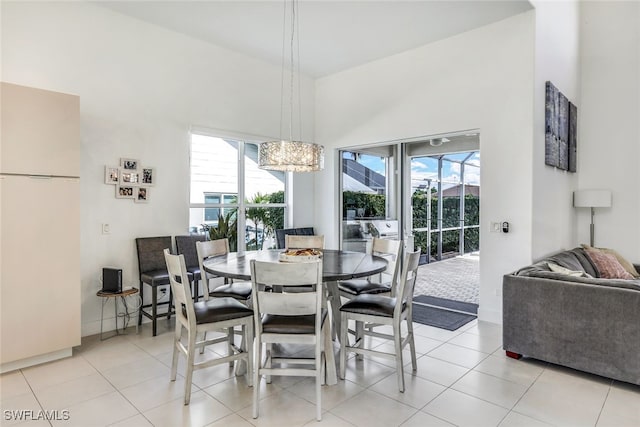 dining space with light tile patterned floors and a notable chandelier