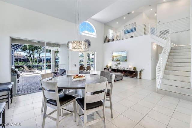 tiled dining room featuring high vaulted ceiling