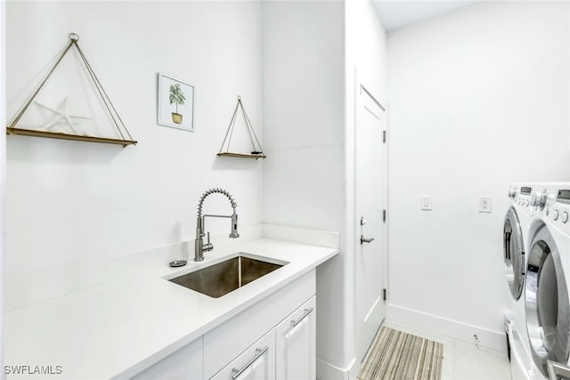 washroom featuring sink, washer and clothes dryer, cabinets, and light tile patterned flooring