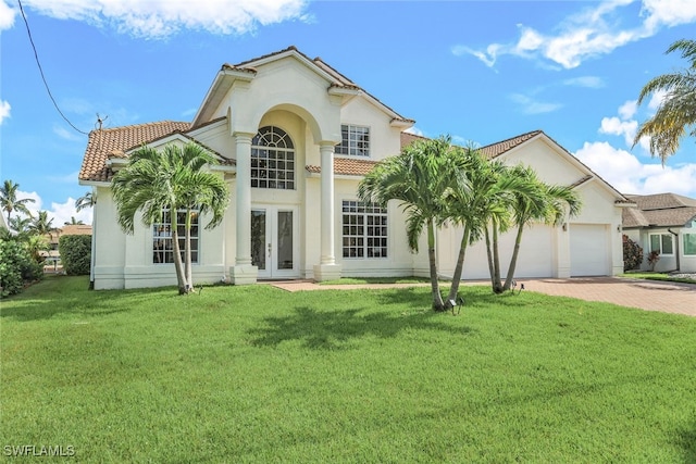 mediterranean / spanish-style home featuring a garage, a front lawn, and french doors