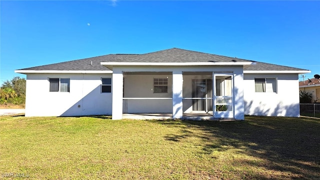 rear view of property featuring a yard