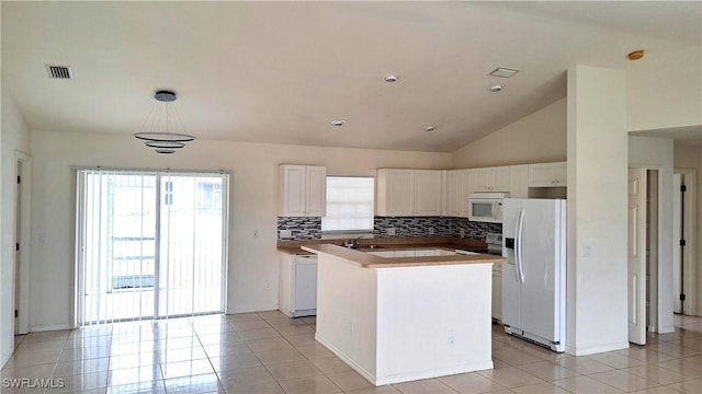 kitchen with white appliances, white cabinets, a center island, decorative light fixtures, and vaulted ceiling