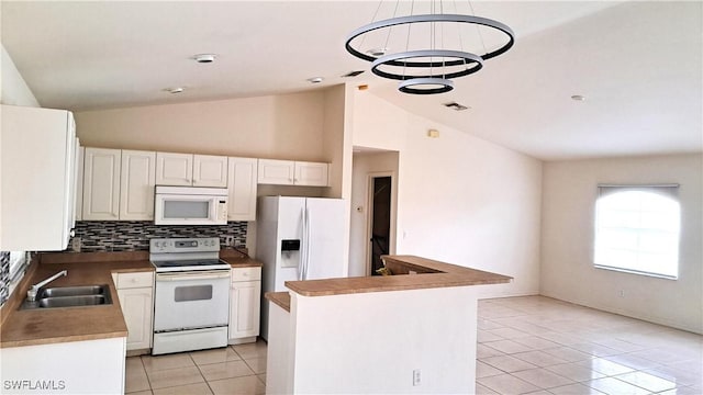 kitchen featuring white appliances, tasteful backsplash, sink, a kitchen island, and vaulted ceiling