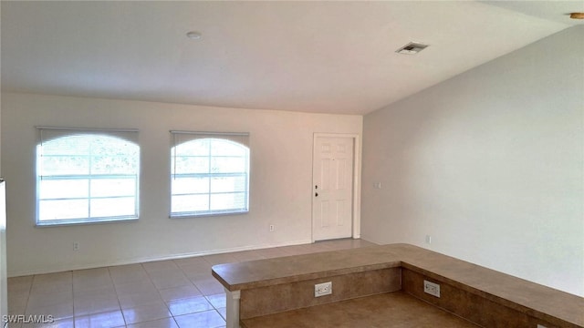 tiled spare room with lofted ceiling