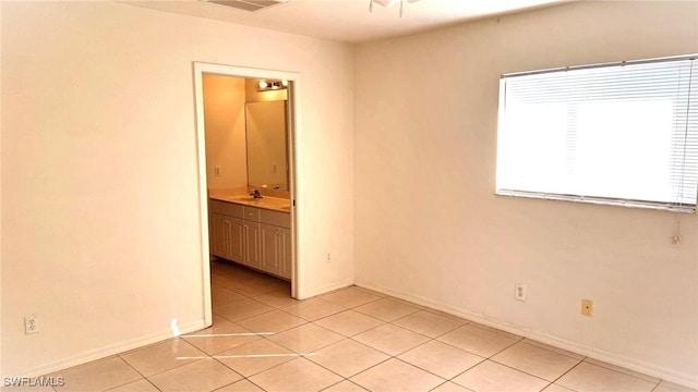 tiled empty room featuring sink