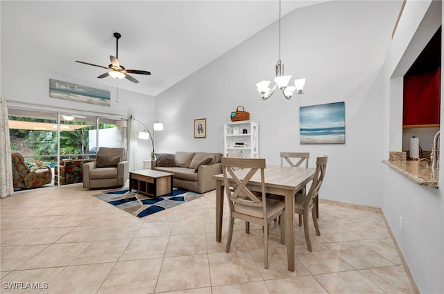 tiled dining area featuring high vaulted ceiling and ceiling fan with notable chandelier