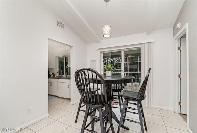 tiled dining room featuring sink and vaulted ceiling