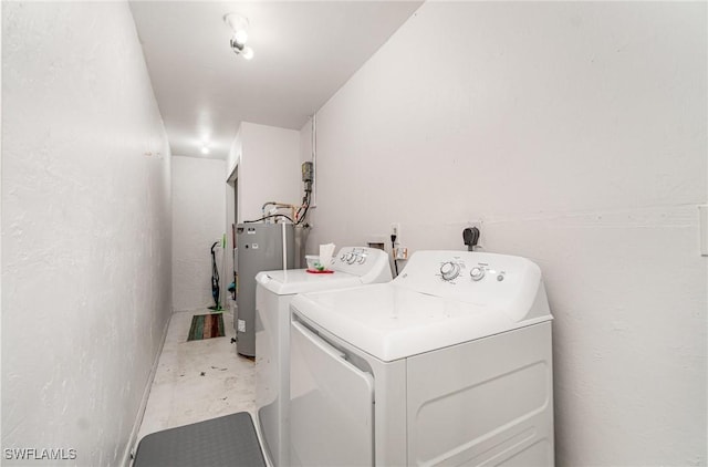 washroom with water heater and washing machine and clothes dryer