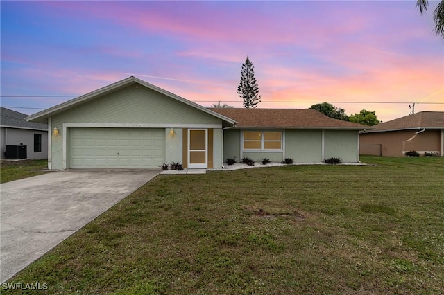 ranch-style house with central AC unit, a yard, and a garage