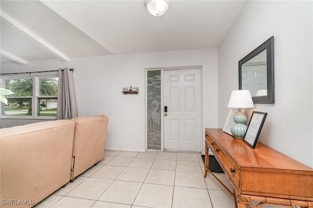 foyer entrance with light tile patterned floors and beam ceiling