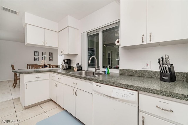 kitchen with sink, light tile patterned floors, white cabinetry, white dishwasher, and kitchen peninsula