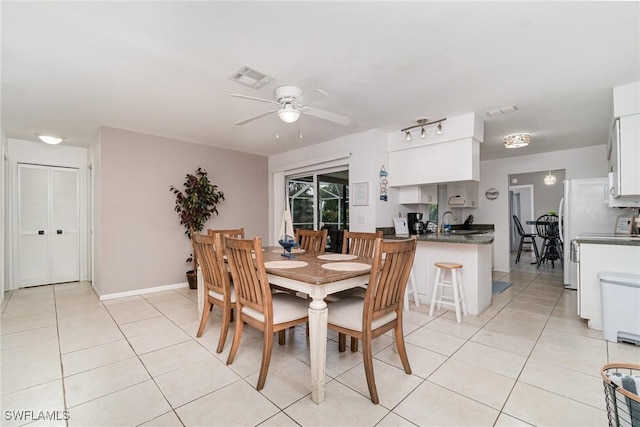 dining space with ceiling fan, sink, and light tile patterned floors