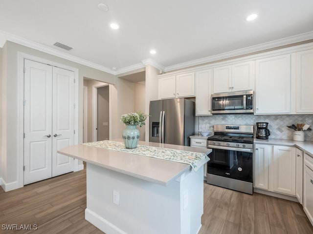 kitchen featuring a kitchen island, tasteful backsplash, appliances with stainless steel finishes, and white cabinets