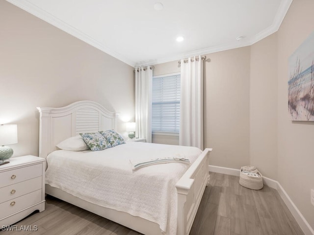 bedroom with ornamental molding and light hardwood / wood-style floors