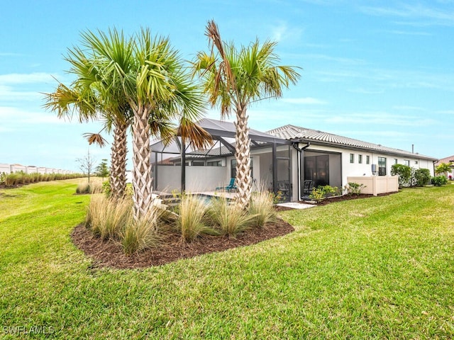 rear view of house featuring a yard and glass enclosure