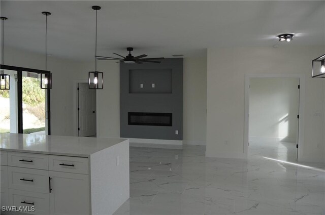 kitchen featuring pendant lighting, ceiling fan, white cabinets, and a kitchen island