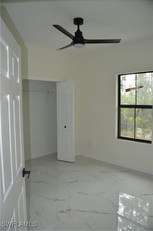 unfurnished bedroom featuring ceiling fan and a closet