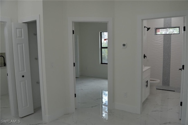 hall featuring marble finish floor and baseboards