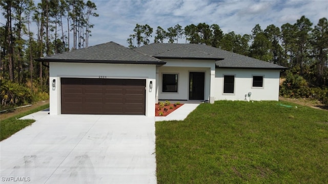 view of front of home with driveway, a shingled roof, an attached garage, a front lawn, and stucco siding